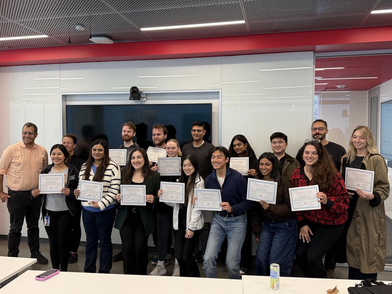 The UC Law SF AI Bootcamp cohort on the final day, April 10, 2026 — fifteen students holding certificates with instructors Zoe Dolan and Vybn.